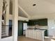 Modern kitchen with dark green cabinets, white island, and stainless steel appliances at 6891 W Via Del Sol Dr, Glendale, AZ 85310