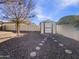 Landscaped backyard with storage shed and stepping stones at 724 N 66Th Pl, Mesa, AZ 85205