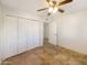 Bright bedroom with tile flooring, double-door closet, and ceiling fan at 724 N 66Th Pl, Mesa, AZ 85205