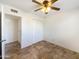 Well-lit bedroom featuring tile floors, a double-door closet and ceiling fan at 724 N 66Th Pl, Mesa, AZ 85205