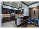 Basement wet bar with dark wood cabinets and granite countertop at 10742 E Greythorn Dr, Scottsdale, AZ 85262