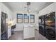 Bright laundry room with island, built-in desk, and large capacity washer/dryer at 12659 E Shadow Ridge Dr, Scottsdale, AZ 85255