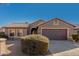 Single-story house with brown exterior, two-car garage, and desert landscaping at 15201 W Verde Ln, Goodyear, AZ 85395