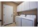 Laundry room with washer, dryer, and upper cabinets at 26053 W Tonopah Dr, Buckeye, AZ 85396