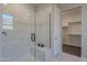 Bathroom with walk-in shower, built-in seat, and spacious closet at 14041 W Monte Vista Rd, Goodyear, AZ 85395