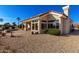 Home's exterior showcasing a covered patio and desert landscaping at 22003 N Tournament Dr, Sun City West, AZ 85375