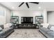 Spacious living room with gray sofas, a large TV, and decorative shelving at 25920 W Tina Ln, Buckeye, AZ 85396