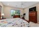 Comfortable bedroom with large window, ceiling fan, and exercise bike at 26822 W Oraibi Dr, Buckeye, AZ 85396
