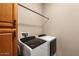 Well-equipped laundry room with washer, dryer, cabinets, and utility sink at 26822 W Oraibi Dr, Buckeye, AZ 85396