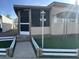 Front entrance of mobile home with screen door and landscaping at 5201 W Camelback W Rd # D69, Phoenix, AZ 85031