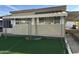 Front view of tan mobile home with awning and landscaping at 5201 W Camelback W Rd # D69, Phoenix, AZ 85031
