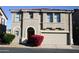 Tan two-story house with a red door and attached two-car garage at 9527 N 82Nd Ln, Peoria, AZ 85345