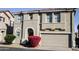 Tan two-story house with a red door and attached two-car garage at 9527 N 82Nd Ln, Peoria, AZ 85345