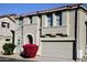 Tan two-story house with a red door and attached two-car garage at 9527 N 82Nd Ln, Peoria, AZ 85345