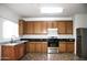 Kitchen with wood cabinets, granite countertops, and stainless steel appliances at 9527 N 82Nd Ln, Peoria, AZ 85345