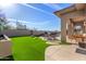 Landscaped backyard with artificial turf, pool, and seating area at 10975 E Greenway Rd, Scottsdale, AZ 85255