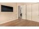 Light-filled bedroom with wood floors, large closet, and mounted TV at 10975 E Greenway Rd, Scottsdale, AZ 85255