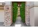 Stone pillars and lush greenery frame the entry to this beautiful home at 10975 E Greenway Rd, Scottsdale, AZ 85255