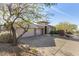 Single-story home with a three-car garage and mature desert landscaping at 10975 E Greenway Rd, Scottsdale, AZ 85255