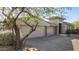 Single-story home with a three-car garage and mature desert landscaping at 10975 E Greenway Rd, Scottsdale, AZ 85255