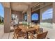 Covered patio with outdoor dining furniture, adjacent to the pool at 10975 E Greenway Rd, Scottsdale, AZ 85255