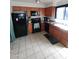 Galley kitchen with wood cabinets and black appliances at 1217 E Fremont Dr, Tempe, AZ 85282