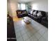 Living room with tiled floors and brown leather sectional sofa at 1217 E Fremont Dr, Tempe, AZ 85282