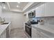 Modern kitchen with white cabinets, marble counters, and stainless steel appliances at 13316 N 26Th Dr, Phoenix, AZ 85029