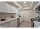 Modern kitchen with white cabinets, marble counters, and stainless steel appliances at 13316 N 26Th Dr, Phoenix, AZ 85029