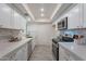 Modern kitchen with white cabinets, marble counters, and stainless steel appliances at 13316 N 26Th Dr, Phoenix, AZ 85029