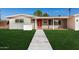 Updated midcentury home with a red front door and nicely landscaped lawn at 1466 E 3Rd St, Mesa, AZ 85203