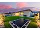 Expansive backyard oasis with a pool, trampoline, and firepit at 3538 E Hazeltine Way, Queen Creek, AZ 85142