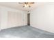 Bedroom with blue carpet, ceiling fan and built-in closet at 10801 W Clair Dr, Sun City, AZ 85351
