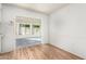 View of a bright dining area with wood-look floors and access to a sunroom at 10801 W Clair Dr, Sun City, AZ 85351