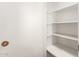 Open pantry with white shelves and brick wall at 10801 W Clair Dr, Sun City, AZ 85351