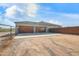 Three-car garage with wood doors and a gated driveway at 28204 N Royce Rd, Queen Creek, AZ 85144