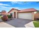 Front view of a tan house with a red tile roof and attached garage at 5203 E Saguaro Cir, Phoenix, AZ 85044