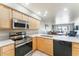 Modern kitchen with light wood cabinets and stainless steel appliances at 635 S 79Th Pl, Mesa, AZ 85208