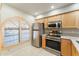 Modern kitchen with stainless steel appliances and light wood cabinets at 635 S 79Th Pl, Mesa, AZ 85208