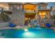 Luxury pool with a waterfall feature and lounge chairs at dusk at 9749 N Fireridge Trl, Fountain Hills, AZ 85268