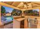 Outdoor kitchen with a built-in grill and bar seating at 14414 N 57Th Way, Scottsdale, AZ 85254