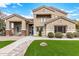 Two-story house with tan exterior, landscaping, and a walkway at 18614 E Caledonia Dr, Queen Creek, AZ 85142