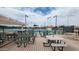 Community patio with tables, chairs, and a view of tennis courts at 2064 S Farnsworth Dr # 18, Mesa, AZ 85209
