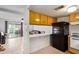 Kitchen with wood cabinets, black fridge, and access to patio at 2449 W Missouri Ave, Phoenix, AZ 85015