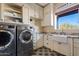 Bright laundry room with white cabinets and granite countertop at 29441 N 64Th St, Cave Creek, AZ 85331