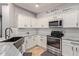 Modern kitchen with white cabinets, granite counters, and stainless steel appliances at 3868 W Ranier Ct, Anthem, AZ 85086