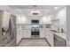 Modern white kitchen with stainless steel appliances and granite countertops at 4200 N Miller Rd # 309, Scottsdale, AZ 85251
