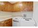 Functional laundry room with washer, dryer, and wood cabinets at 4531 E Quartz Mountain Rd, Paradise Valley, AZ 85253