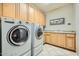 Bright laundry room, washer, dryer, cabinets, and tile floor at 8300 E Dixileta Dr # 281, Scottsdale, AZ 85266