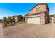 Two-story house with beige exterior, stone accents, and a three-car garage at 10746 W Desert Elm Ln, Peoria, AZ 85383